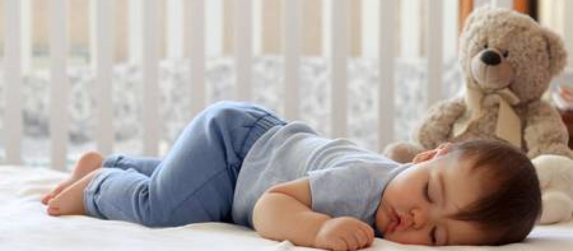 96131177-funny-baby-sleeping-on-his-stomach-on-bed-at-home-child-daytime-bottom-up-sleeping-position
